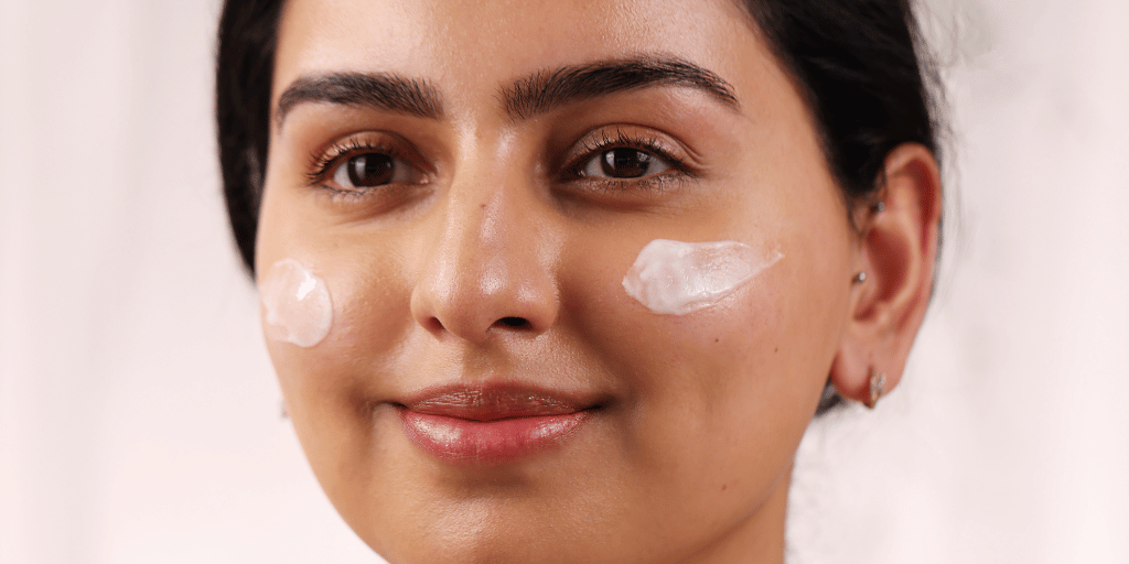 girl smiling with face cream swiped across both cheeks